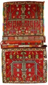 “Vintage Qashqai saddlebag with floral vase motif on red background” “Handwoven Persian saddlebag with tree and flower design” “Tribal Qashqai textile in red with decorative floral pattern” “Antique-style South Iranian saddlebag with botanical motif”