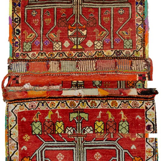 “Vintage Qashqai saddlebag with floral vase motif on red background” “Handwoven Persian saddlebag with tree and flower design” “Tribal Qashqai textile in red with decorative floral pattern” “Antique-style South Iranian saddlebag with botanical motif”