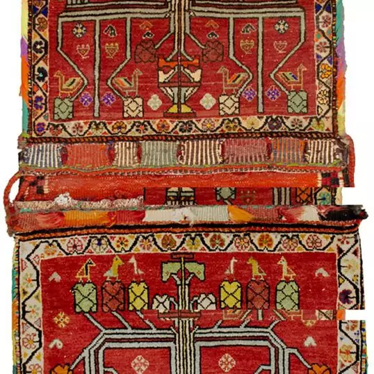 “Vintage Qashqai saddlebag with floral vase motif on red background” “Handwoven Persian saddlebag with tree and flower design” “Tribal Qashqai textile in red with decorative floral pattern” “Antique-style South Iranian saddlebag with botanical motif”