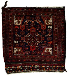 alt="Vintage Baluch tribal bag with dowry tufts and goat motifs" alt="Handwoven Baluch bag with red kilim S-design and flowerheads" alt="Antique Baluch wool bag with tribal symbolism from Northeast Iran" alt="Collectible Persian tribal bag with rich colours and unique details"