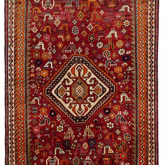 alt="Qashqai rug with red field, cream medallion, and tribal animal motifs" alt="Vintage Persian rug with peacocks, rams, and stylised flowers" alt="Fun Qashqai tribal rug from South Iran with narrow borders" alt="Characterful nomadic rug with symbolic animals and floral elements"