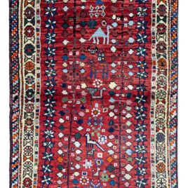 alt="Shiraz rug with camels, peacocks, trees, and abrushed red field" alt="Tribal Persian rug from Shiraz with animal and nature motifs" alt="Southern Iranian rug with cream floral border and red field" alt="Unusual Shiraz wool rug with charming folk art design"