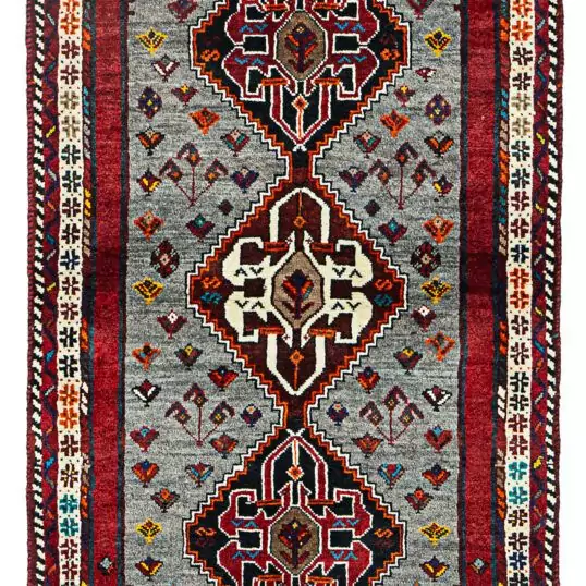 alt="Grey-ground Qashqai rug with scarab beetle medallions and red border" alt="Tribal Persian rug with cream central medallion and abrushed field" alt="Handwoven Qashqai wool rug with symbolic motifs and natural dyes" alt="Rare Qashqai carpet with scarab design and elegant colour contrast"
