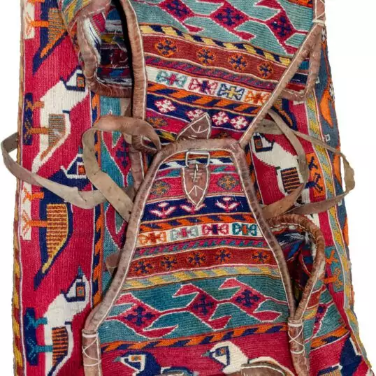 alt="Qashqai Rakhtekhab bag with sumak weave, partridges, goats, and leather trim" alt="Vintage tribal Mafrash bag in turquoise, red, blue, and orange with intact handles" alt="Sumak-woven nomadic bedding bag with animal motifs and collector value" alt="Traditional Qashqai storage bag repurposable as ottoman or table base"