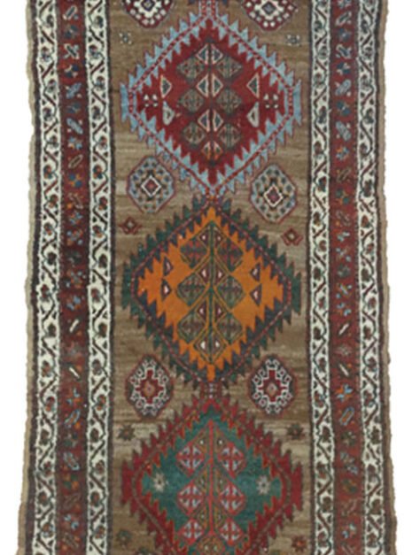 “Antique Kordi runner with grey-brown ground and red borders” “Persian tribal rug with medallion design and white guard borders” “Handwoven Kurdish runner with unique earthy colour palette” “Vintage Persian runner for hallway or corridor décor”