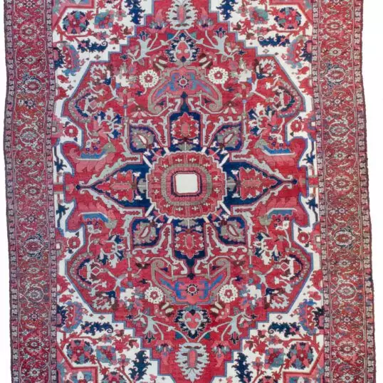 alt="Gharadagh Heriz carpet with red ground and bold medallion" alt="Vintage Persian rug with Samavar border and white spandrels" alt="Large Heriz rug with stylised floral design from Northwest Iran" alt="Restored antique Heriz carpet with bold colours and classic motifs"