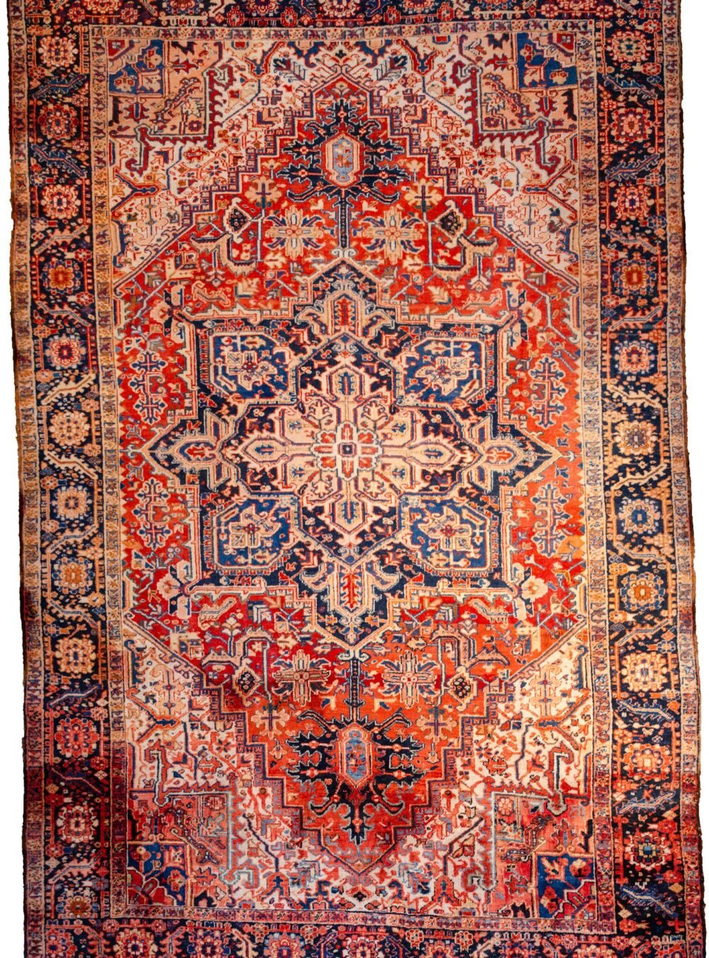 alt="Heriz carpet with bold medallion and terracotta red ground" alt="Persian rug with white spandrels and geometric design" alt="Classic Heriz rug with flowing border and good pile" alt="Antique Heriz carpet with minor wear and strong colours"