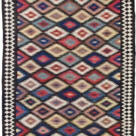 This rare and beautifully woven Saveh kilim is a testament to the exceptional quality and artistry that emerges from even the lesser-known weaving regions of Iran. While the city of Saveh and its surrounding villages are not major kilim production centres, the pieces that do originate from there are often outstanding in both design and craftsmanship—and this example is no exception. The kilim features a dazzling all-over lozenge design, bold and rhythmic, creating visual energy that draws the eye and enlivens any space. The field is framed by a soft cream border, which not only softens the dynamic central pattern but also elevates the overall composition with elegance and balance. Woven using traditional flatweave techniques and naturally dyed wool, this piece is lightweight yet durable, and easy to use in various interior settings—from rustic and eclectic to contemporary and minimalist. Kilims like this are often underrated, yet they represent a sophisticated blend of utility, tradition, and decorative appeal. This piece, in particular, stands out as an engaging and collectible work of woven art. ✅ Key Features: Origin: Saveh, Iran Type: Kilim (flatweave) Design: Dazzling lozenge pattern Border: Cream, with geometric motifs Material: Wool Dye: Natural vegetable dyes Condition: Excellent Size: (Insert dimensions if available) Use: Wall hanging, floor rug, layering textile, collector’s item ✅ Why This Kilim? Rare in origin and rich in style, this Saveh kilim brings colour, movement, and authentic craftsmanship to any interior—a true decorative gem. ✅ Call to Action Celebrate the art of flatweave with this vibrant Saveh kilim—a stylish and distinctive piece woven with heritage and flair.