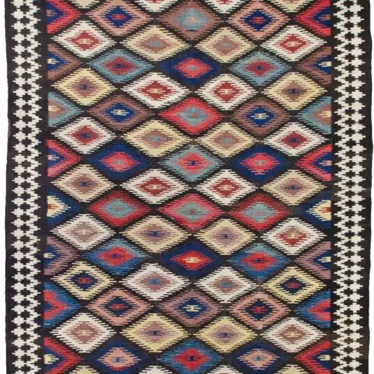 This rare and beautifully woven Saveh kilim is a testament to the exceptional quality and artistry that emerges from even the lesser-known weaving regions of Iran. While the city of Saveh and its surrounding villages are not major kilim production centres, the pieces that do originate from there are often outstanding in both design and craftsmanship—and this example is no exception. The kilim features a dazzling all-over lozenge design, bold and rhythmic, creating visual energy that draws the eye and enlivens any space. The field is framed by a soft cream border, which not only softens the dynamic central pattern but also elevates the overall composition with elegance and balance. Woven using traditional flatweave techniques and naturally dyed wool, this piece is lightweight yet durable, and easy to use in various interior settings—from rustic and eclectic to contemporary and minimalist. Kilims like this are often underrated, yet they represent a sophisticated blend of utility, tradition, and decorative appeal. This piece, in particular, stands out as an engaging and collectible work of woven art. ✅ Key Features: Origin: Saveh, Iran Type: Kilim (flatweave) Design: Dazzling lozenge pattern Border: Cream, with geometric motifs Material: Wool Dye: Natural vegetable dyes Condition: Excellent Size: (Insert dimensions if available) Use: Wall hanging, floor rug, layering textile, collector’s item ✅ Why This Kilim? Rare in origin and rich in style, this Saveh kilim brings colour, movement, and authentic craftsmanship to any interior—a true decorative gem. ✅ Call to Action Celebrate the art of flatweave with this vibrant Saveh kilim—a stylish and distinctive piece woven with heritage and flair.