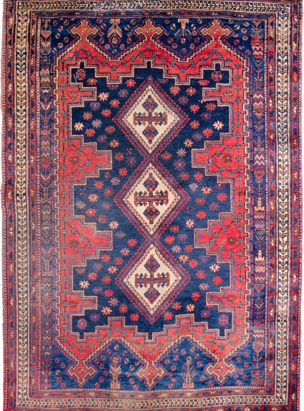alt="Afshar Sirjan rug with triple cream medallions on blue and red field" alt="Hand-knotted Persian rug with geometric borders and tribal motifs" alt="Vintage Afshar rug with stylized bushes and blue ground medallions" alt="Wide Afshar Sirjan carpet with light wear and strong visual design"