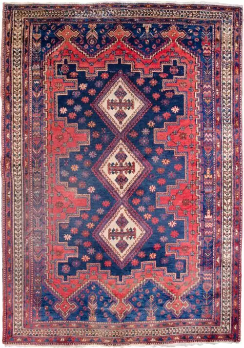 alt="Afshar Sirjan rug with triple cream medallions on blue and red field" alt="Hand-knotted Persian rug with geometric borders and tribal motifs" alt="Vintage Afshar rug with stylized bushes and blue ground medallions" alt="Wide Afshar Sirjan carpet with light wear and strong visual design"