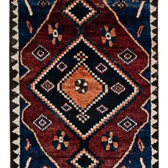 alt="Hand-knotted Bakhtiari Gabbeh rug with lozenge medallion and floral motifs" alt="Deep red Bakhtiari Gabbeh carpet with blue and orange lozenge design" alt="Persian Gabbeh rug with flower head medallion and intricate floral patterns" alt="Traditional Bakhtiari Gabbeh runner with jagged border and rich colors"