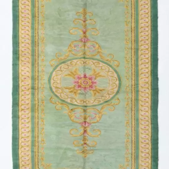 A full, direct overhead view of the Hand-Knotted Vintage Spanish Rug 1950s Deep Green against a white background. This shot clearly displays the 639 x 295cm dimensions, the central floral medallion, the light green field, and the thick, ornate dark green border with gold detailing.